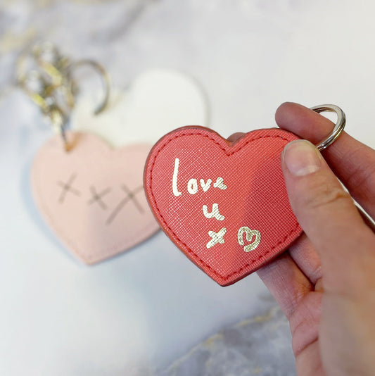 Heart-shaped keychain with 'love u x' text held by a hand against a light background - Mums