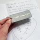 Handwritten card with a fathers day keyring and a child's drawing on a white background